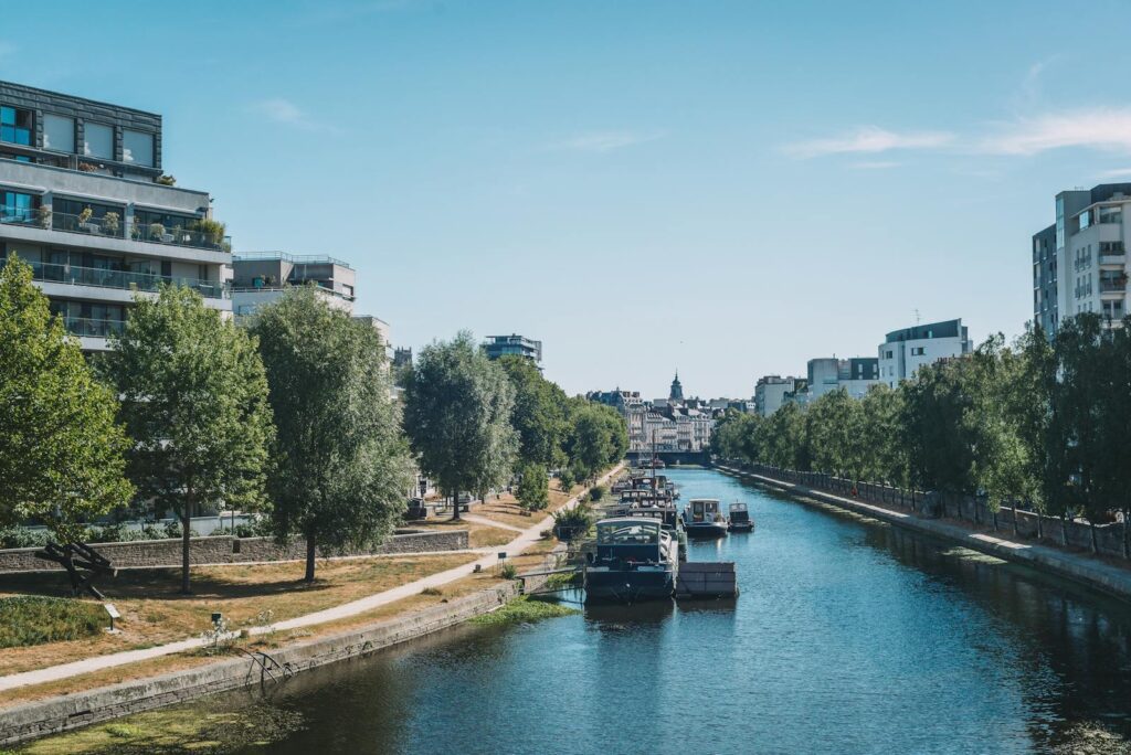 Charming riverside view in Rennes with boats and modern buildings.