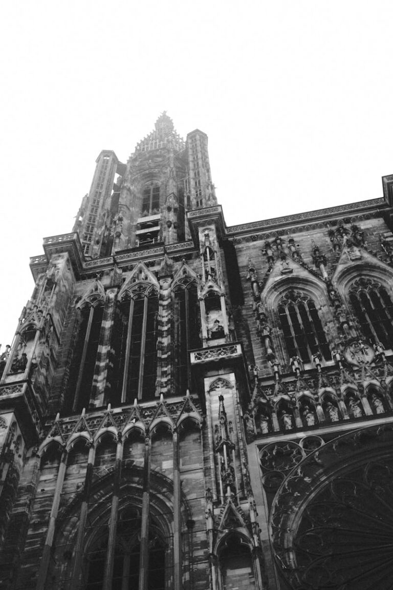 Striking view of a Gothic cathedral tower, captured in black and white, showcasing intricate architecture.