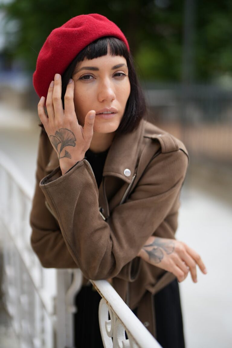 Elegant portrait of a woman in a red beret and brown jacket, posing thoughtfully outdoors in Geneva.