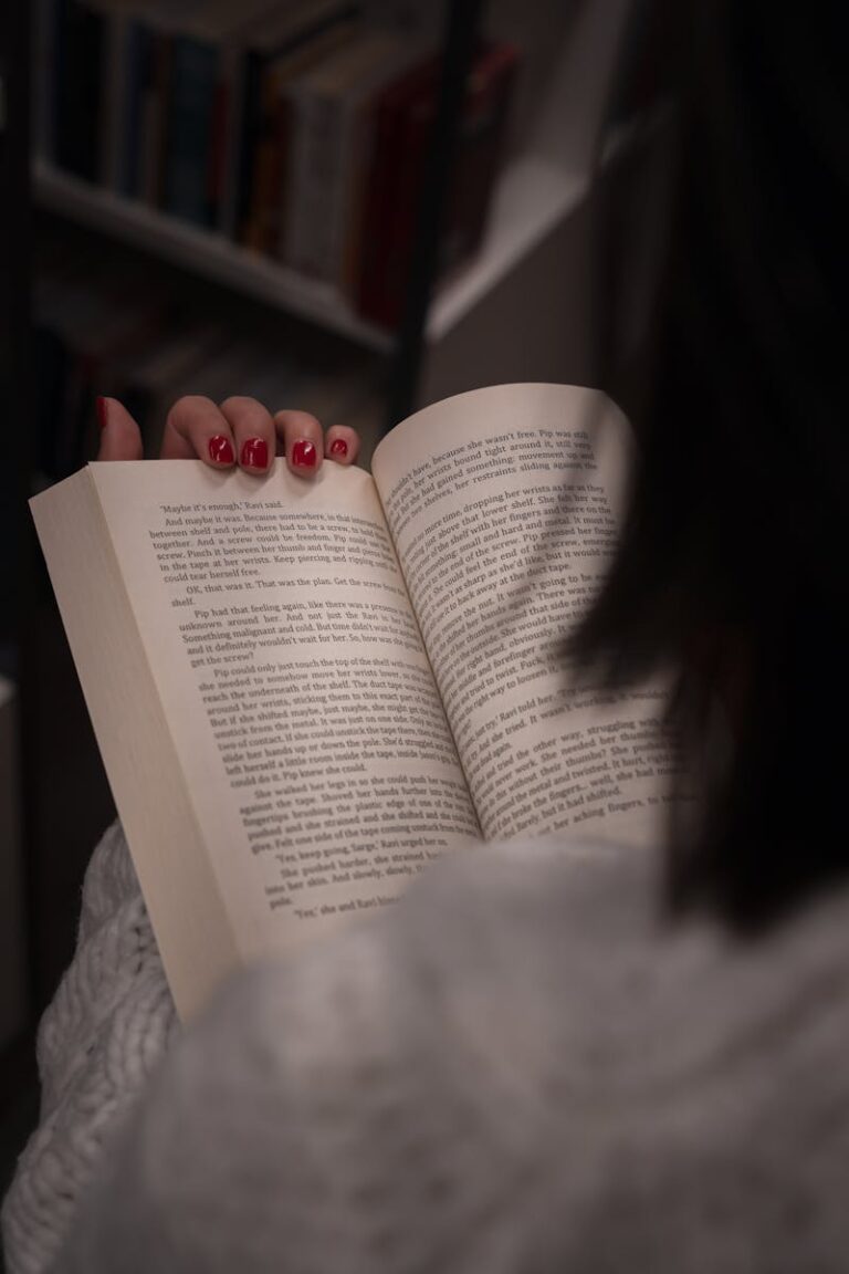 Focused on a woman reading a book in a cozy, quiet library environment.