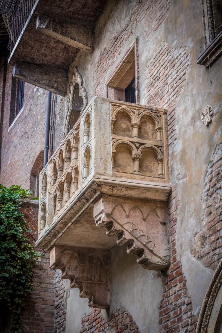 Classic brick building with famous Verona balcony, evocative of historical romance.