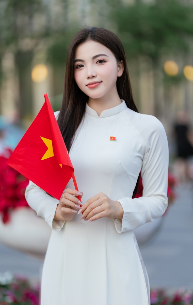 A young woman holds the vietnamese flag proudly.