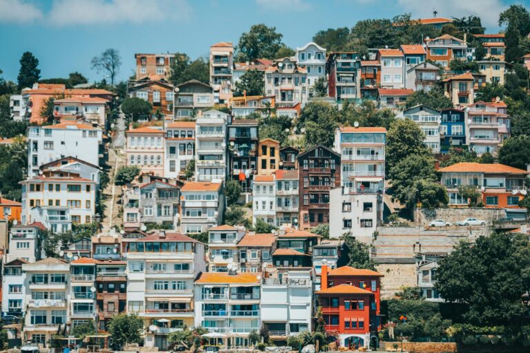 Vibrant view of colorful hillside buildings, showcasing diverse architectural styles in a lush urban setting.