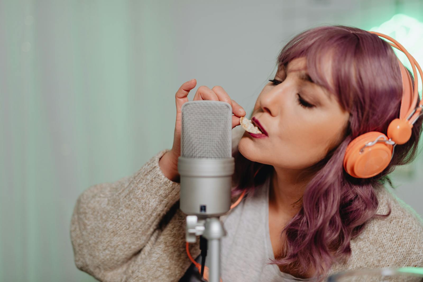 Young woman with a microphone and headphones indoors.