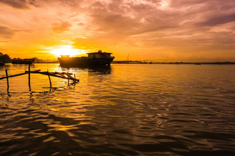 Silhouette of boat on river during sunset
