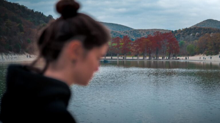 A young woman standing in front of a body of water
