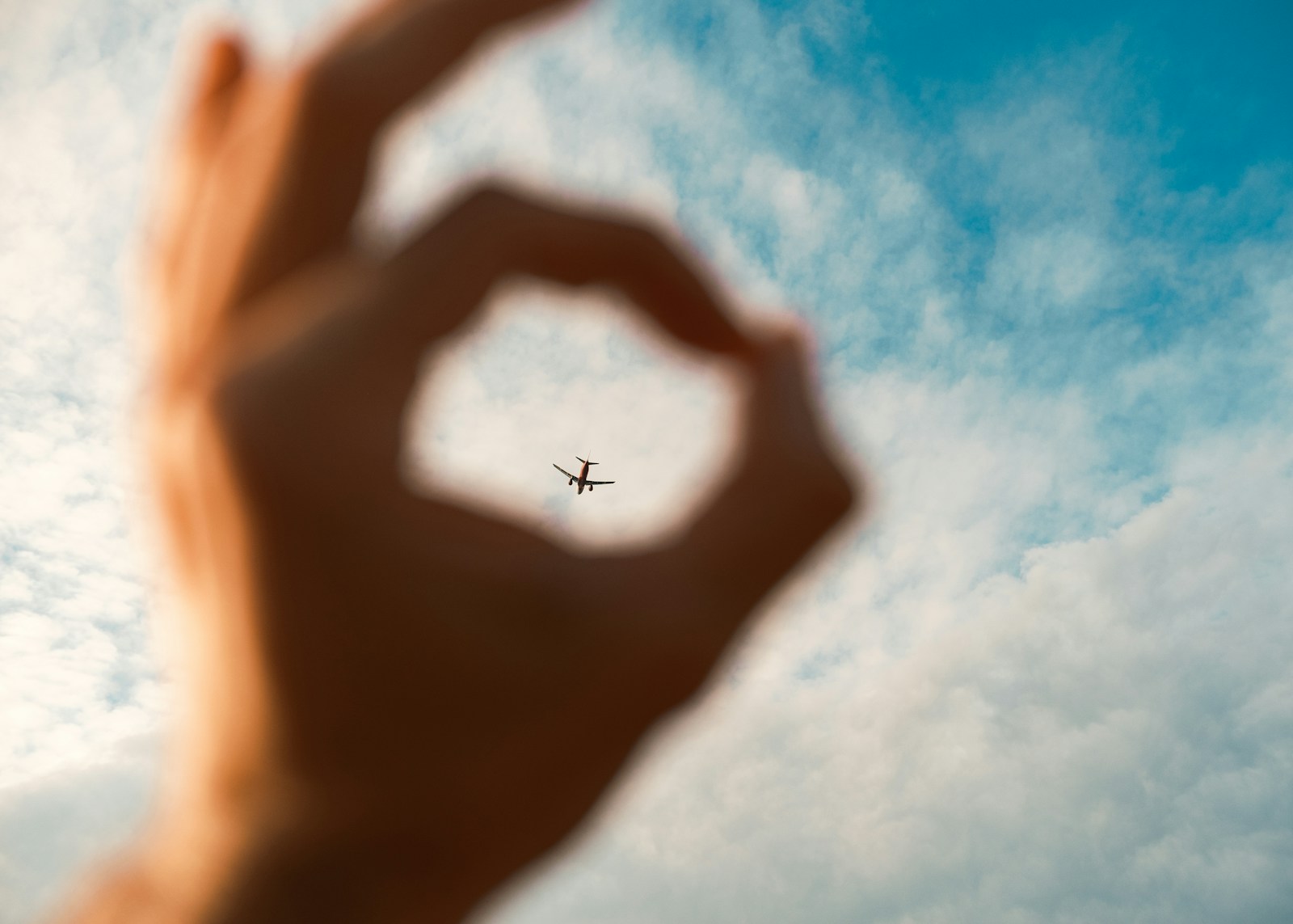 Where the River Sings: A Journey Through the Magical Isles of My Tho and Ben Tre A hand making a heart shape with an airplane in the background