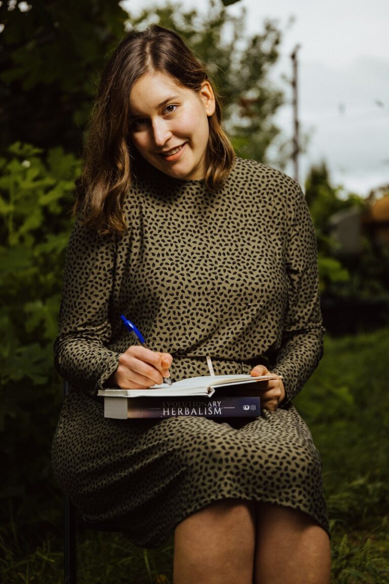 A woman sitting in a chair writing on a book