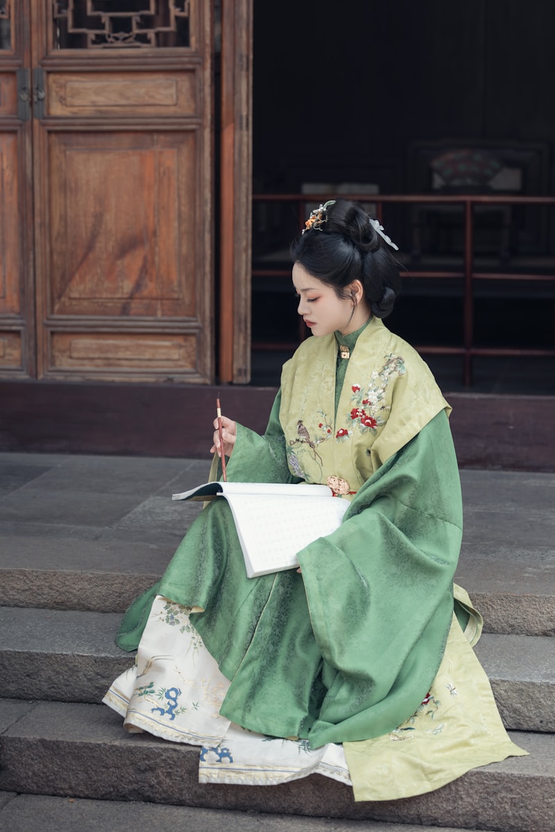 A woman writes while wearing traditional attire.