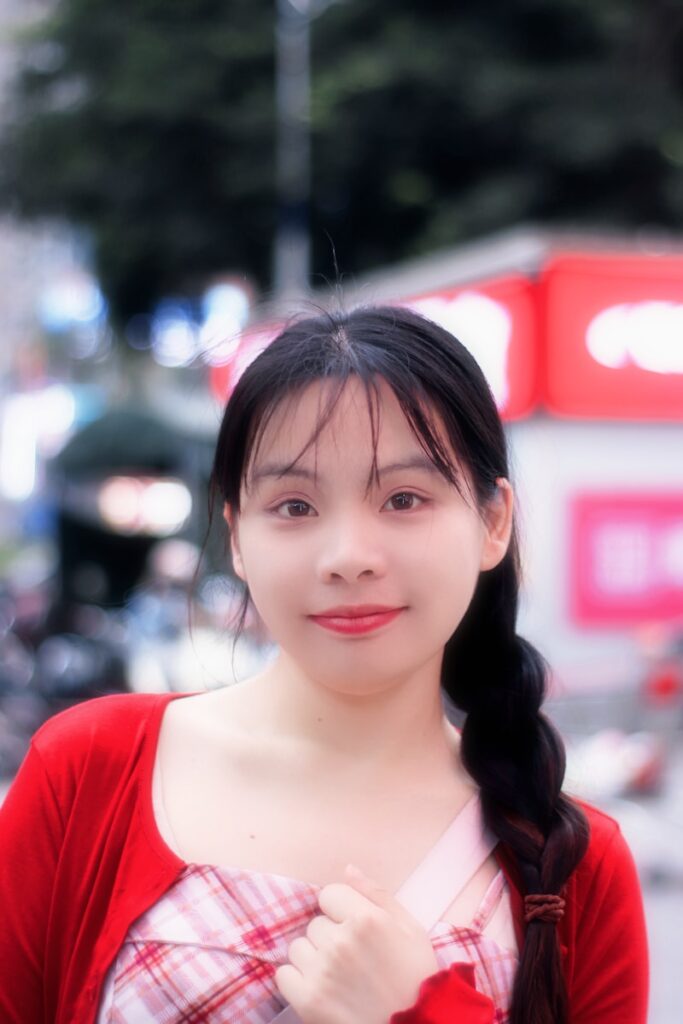 A young woman smiles in a busy urban setting.