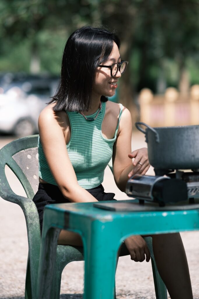 A woman sitting at a table with a pot on top of it