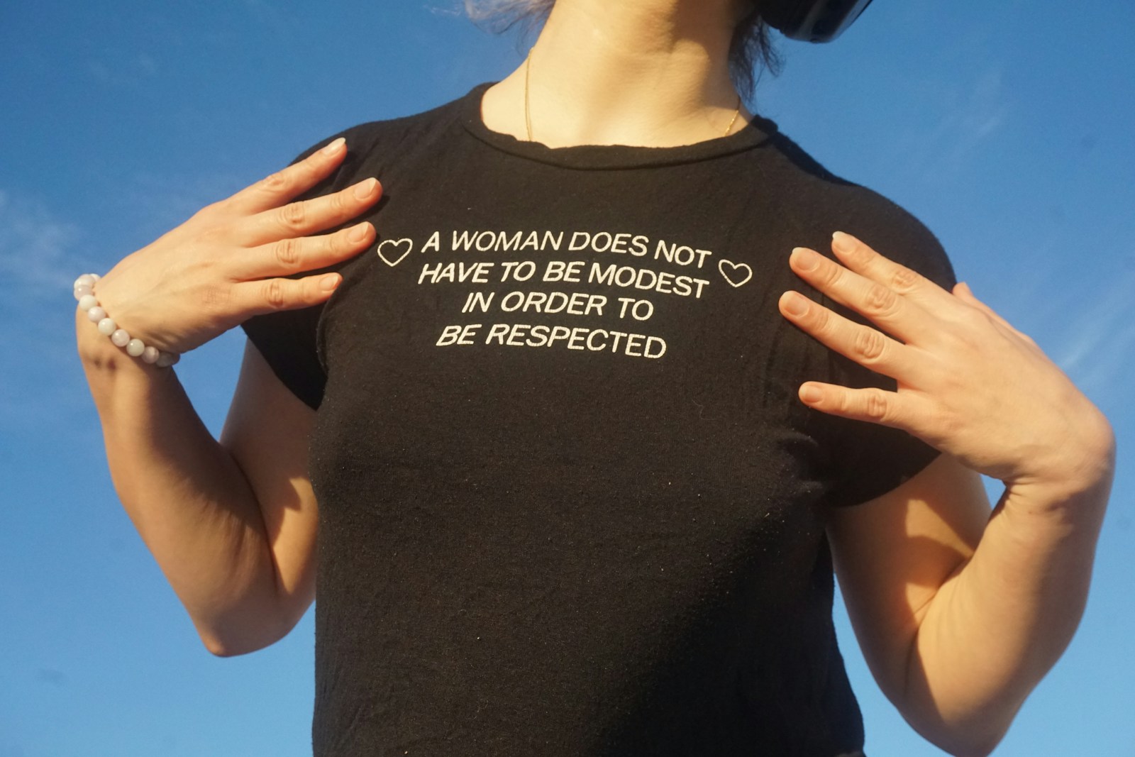 A woman wearing a t - shirt that says a woman doesn't have to