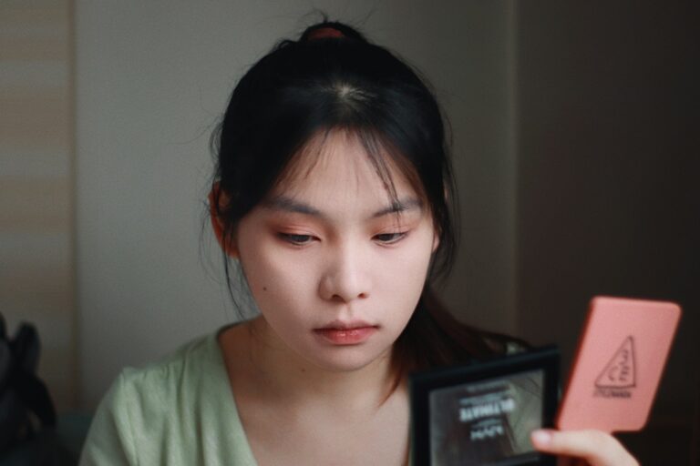 A Woman is looking in a compact mirror.