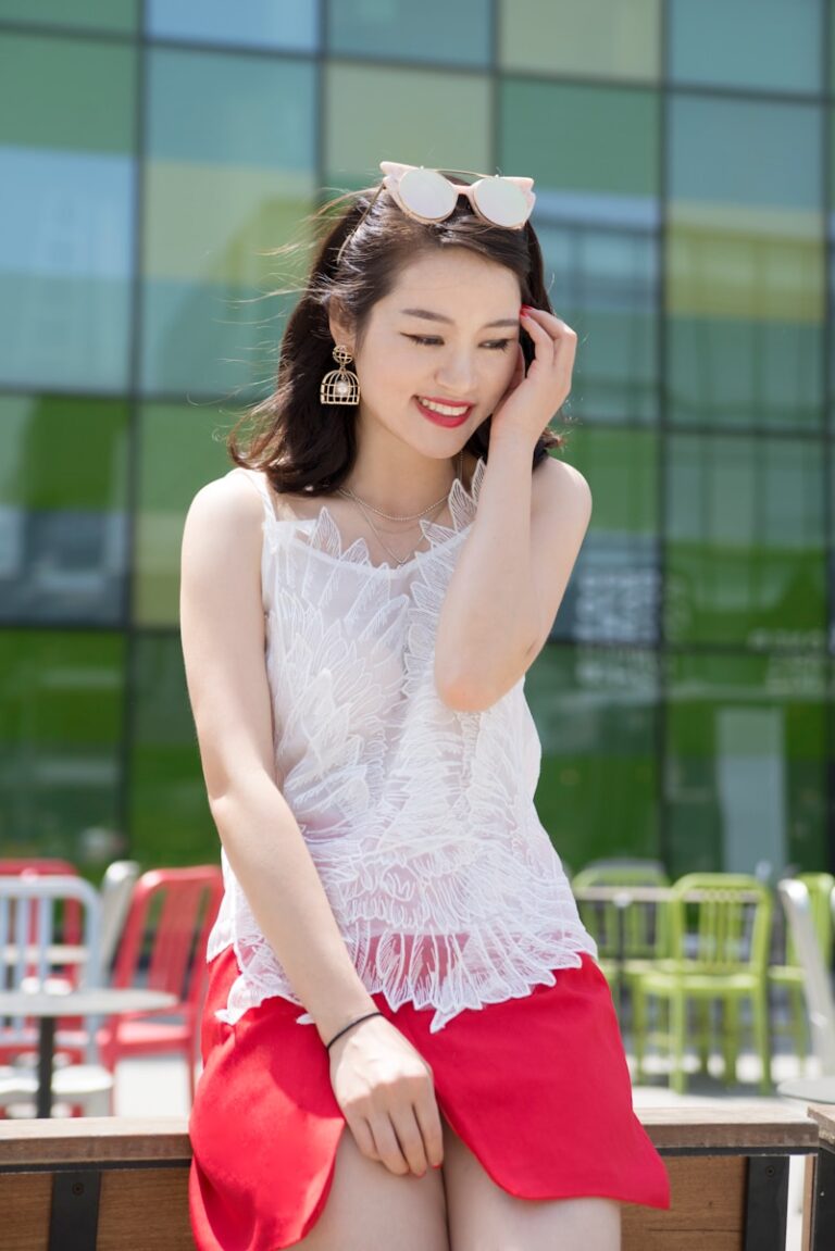 woman holding her head while sitting on table