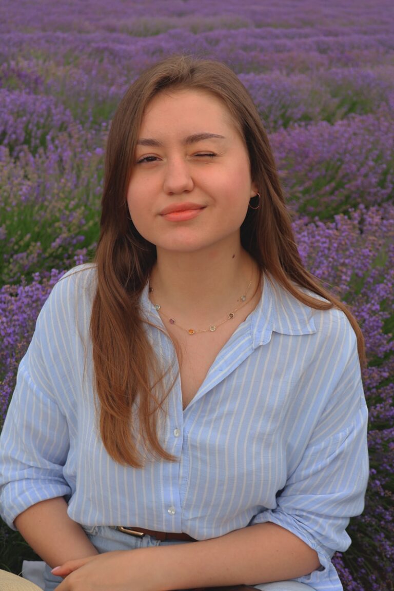 A woman standing in front of a field of purple flowers