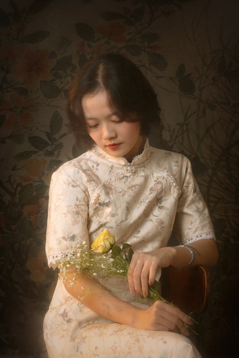 A woman in a white dress holding a yellow rose