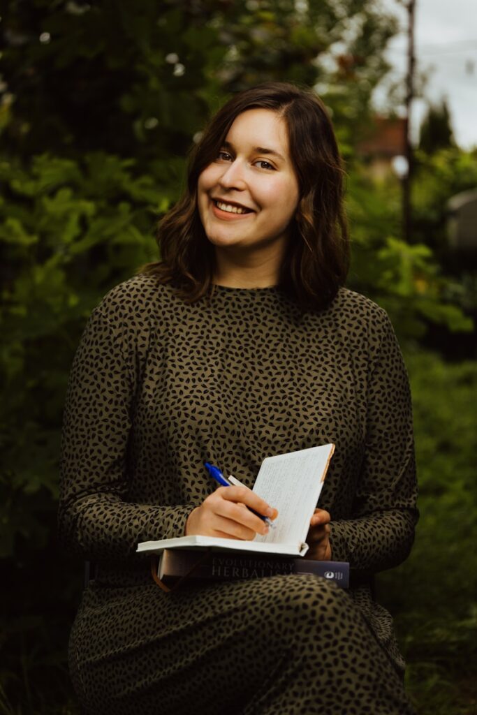 A woman sitting on a bench holding a pen and paper