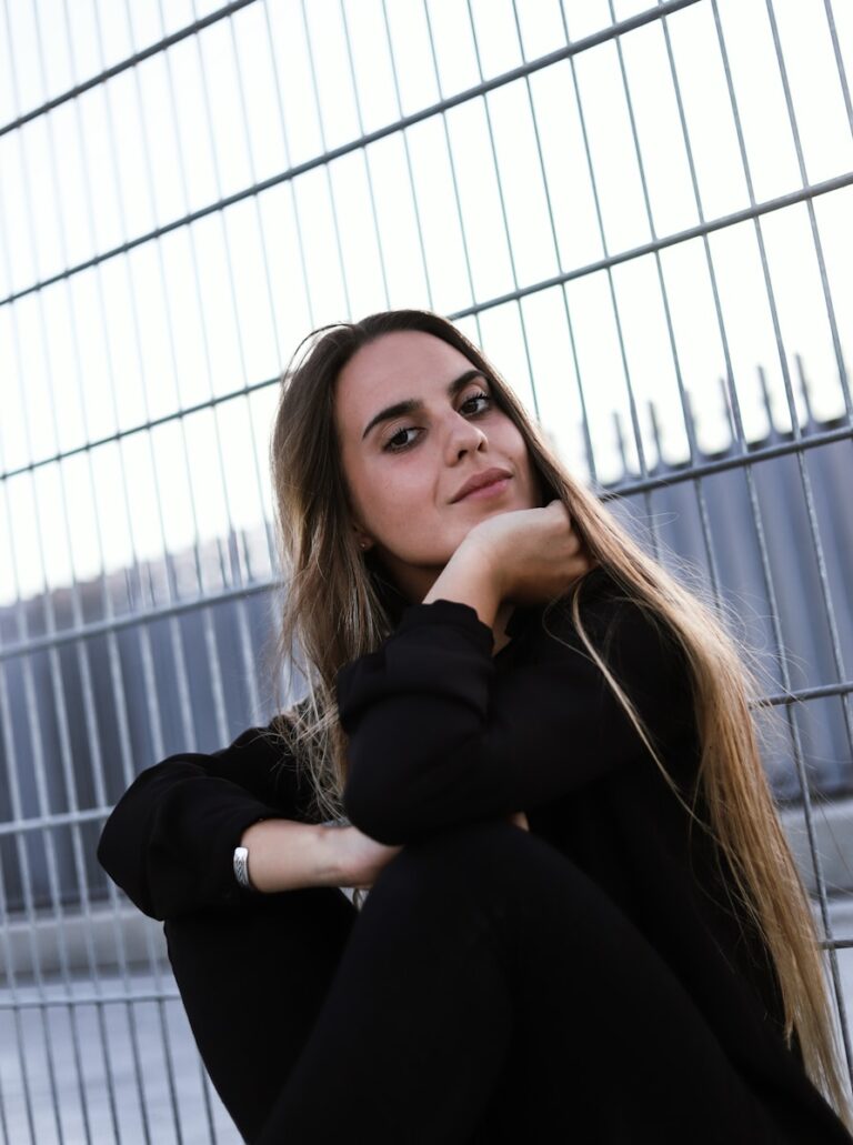 a woman leaning on a fence