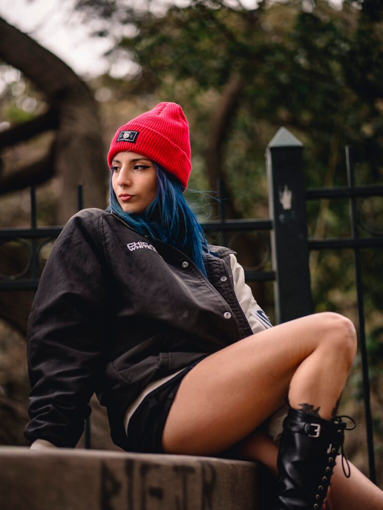 a woman sitting on a bench wearing a red hat