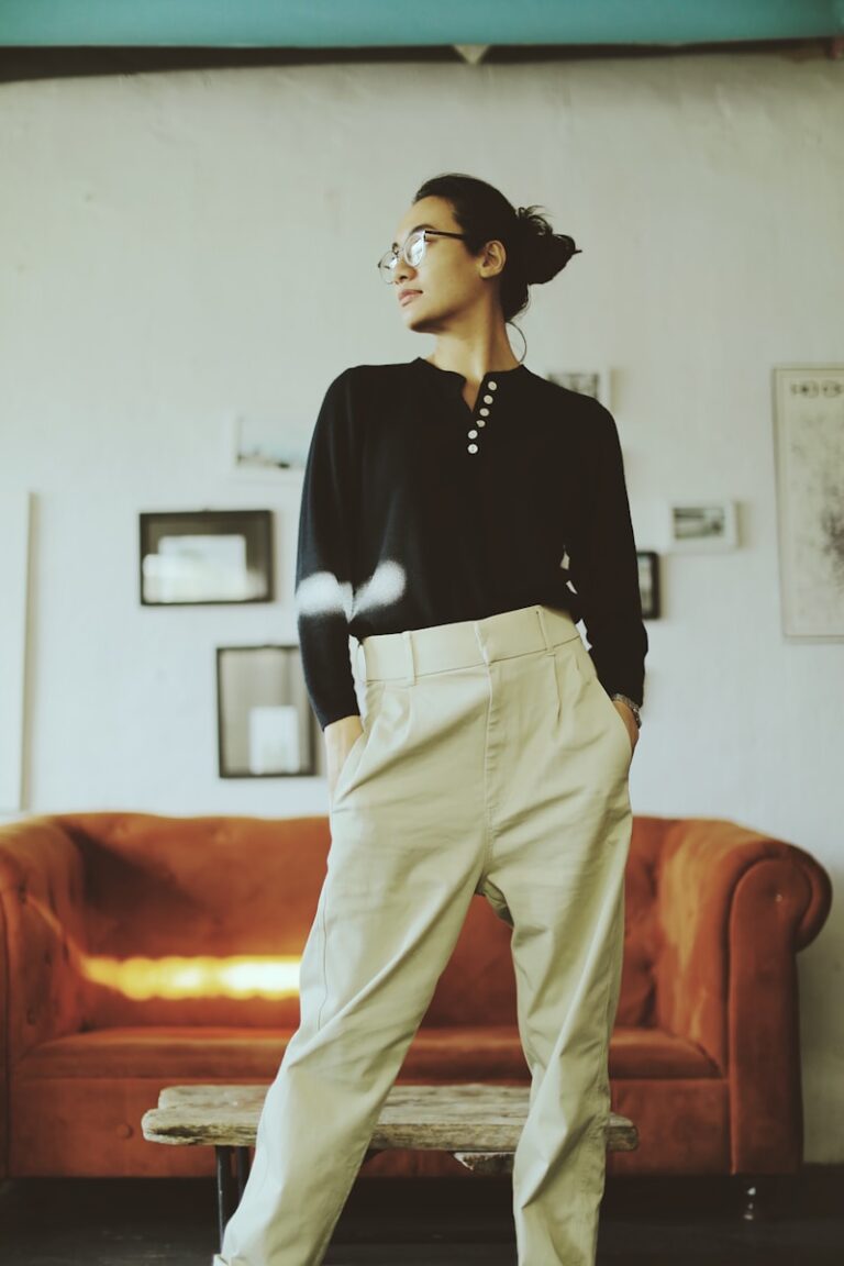 woman in black long sleeve shirt and beige pants standing on orange sofa